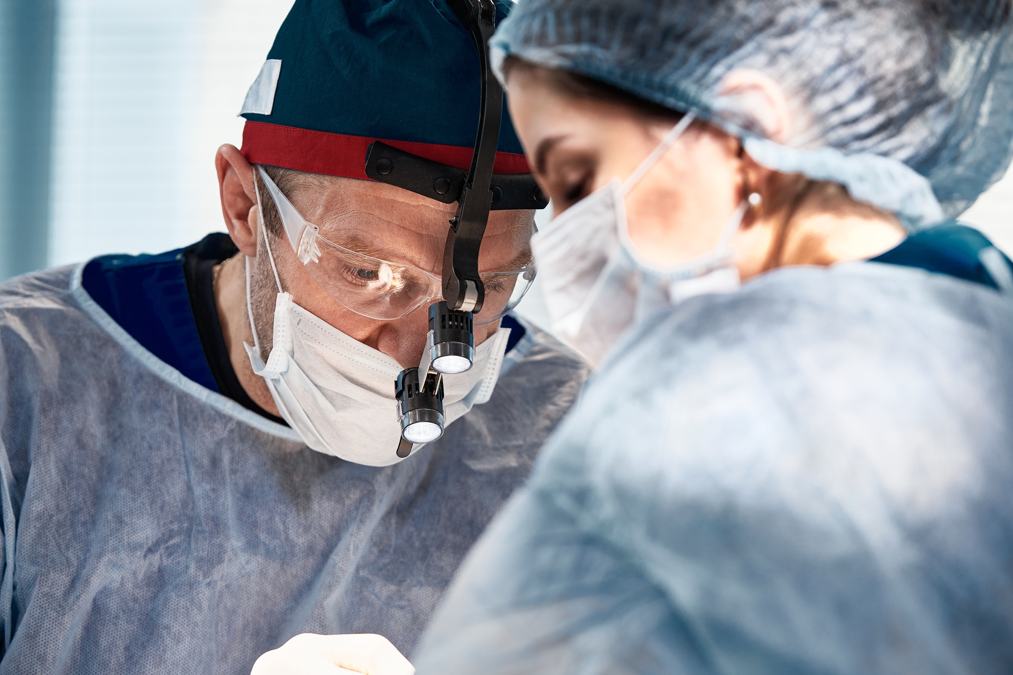 Surgeons men and women during an operation on the operating table, doctors in modern equipment